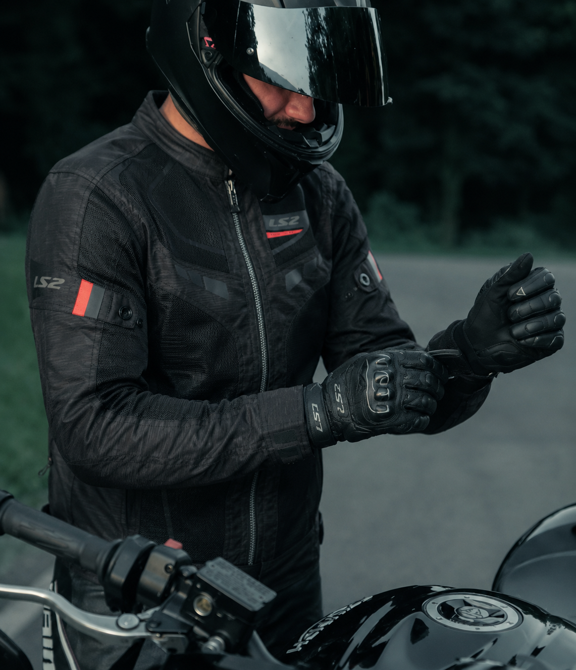 Motorista abrochándose sus guantes de motero